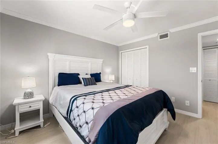 Bedroom featuring ceiling fan, a closet, crown molding, and light hardwood / wood-style floors
