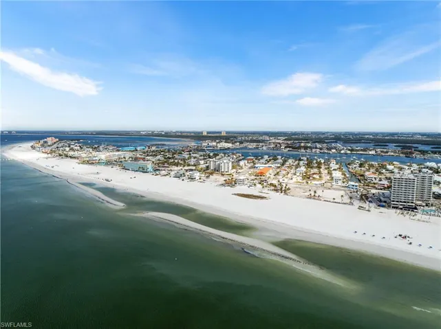 Birds eye view of property with a view of the beach and a water view