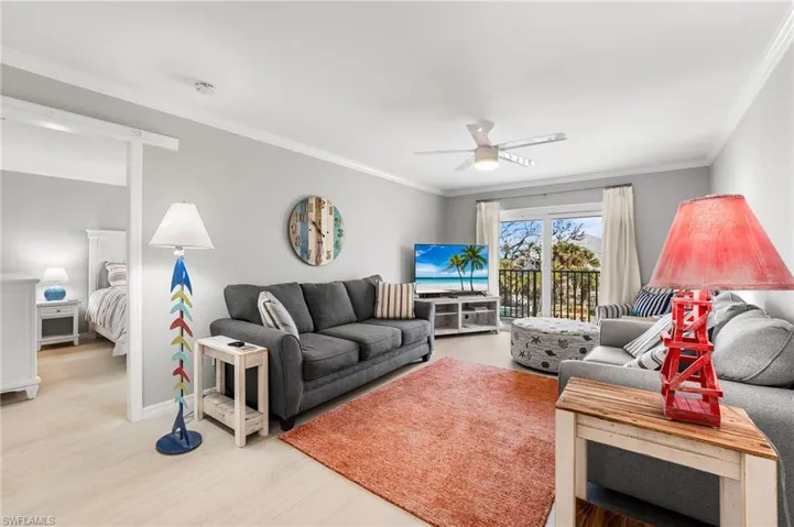 Living room featuring ceiling fan, light hardwood / wood-style floors, and crown molding