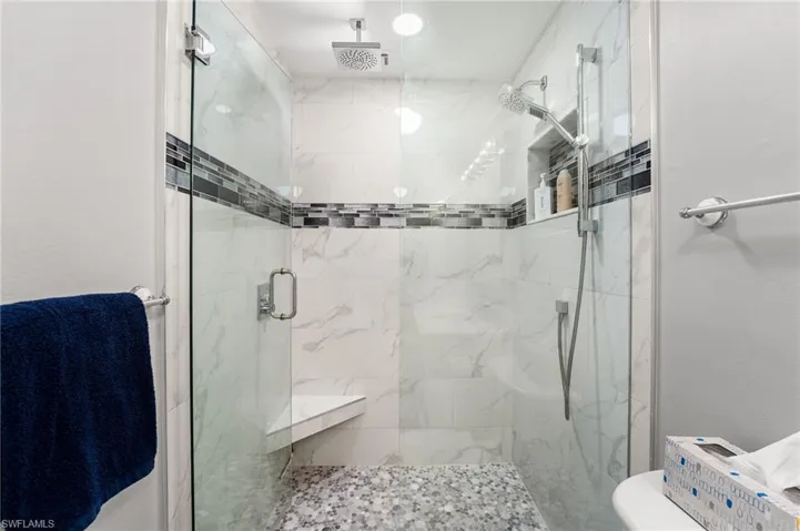 Bathroom featuring toilet and a shower with door