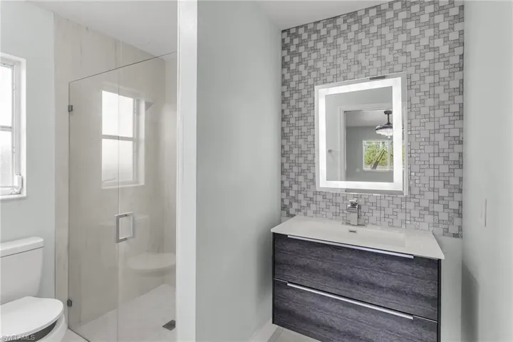 Bathroom with toilet, vanity, and walk in shower