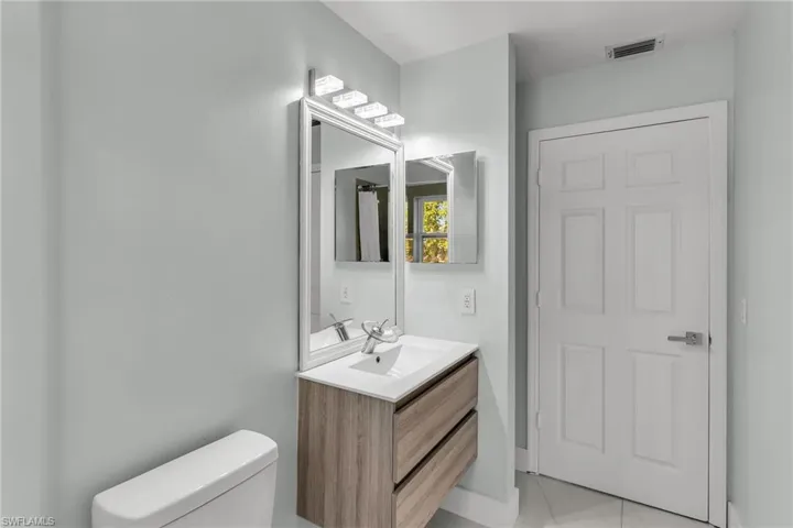 Bathroom with toilet, vanity, and tile patterned flooring