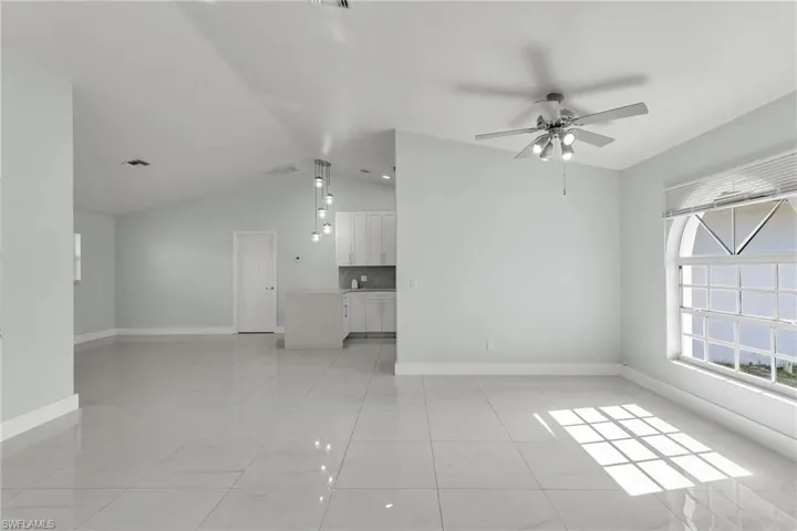 Unfurnished living room with lofted ceiling and ceiling fan