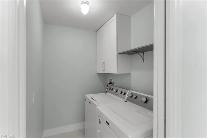 Washroom with washing machine and dryer and cabinets
