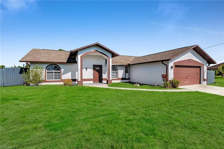 Single story home with a front yard and a garage