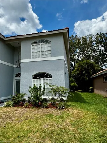 View of side of home with a yard and stucco siding