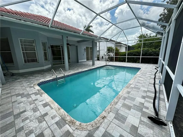Outdoor pool with a patio area, ceiling fan, and a lanai