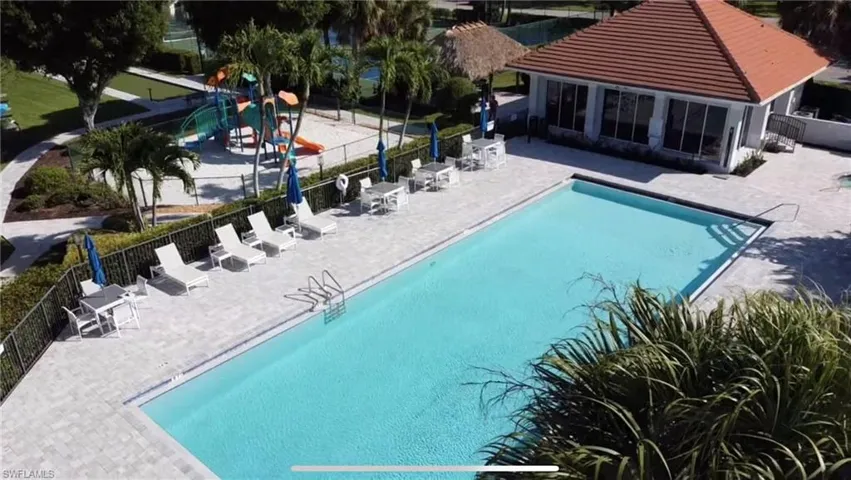 Community pool featuring a patio area and fence