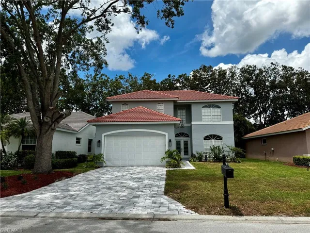 Mediterranean / spanish-style home featuring a garage, a tiled roof, stucco siding, a front yard, and decorative driveway