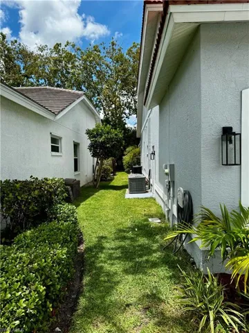 View of grassy yard with central air condition unit