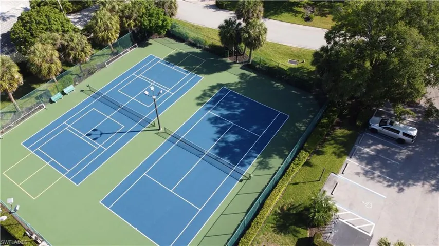 View of tennis court featuring fence