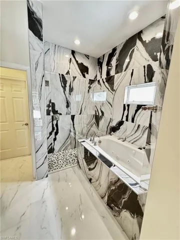 Full bath featuring a marble finish shower, a jetted tub, marble tiled floors, and recessed lighting