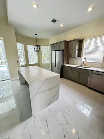 Kitchen featuring stainless steel appliances, a sink, open shelves, recessed lighting, and a center island