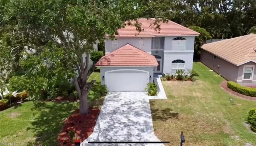 Mediterranean / spanish-style home with a front lawn, stucco siding, driveway, an attached garage, and a tile roof