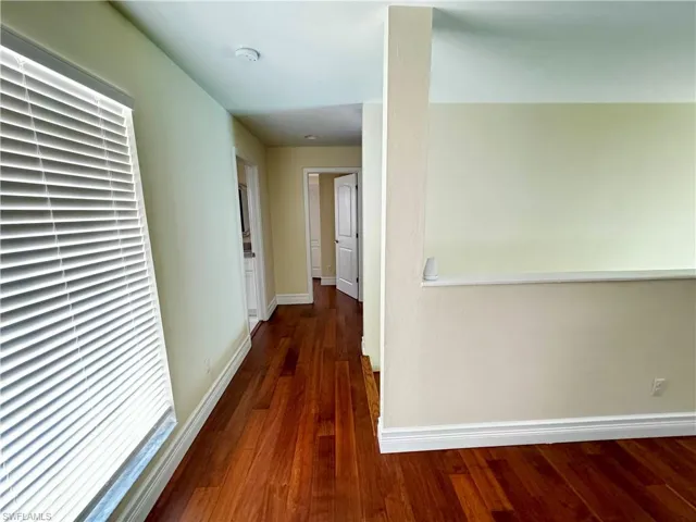 Hallway featuring wood finished floors and baseboards