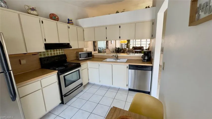 Kitchen featuring white cabinetry, appliances with stainless steel finishes, tasteful backsplash, and sink