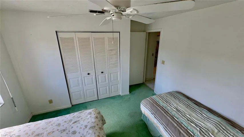 Unfurnished bedroom featuring a closet, carpet floors, and ceiling fan