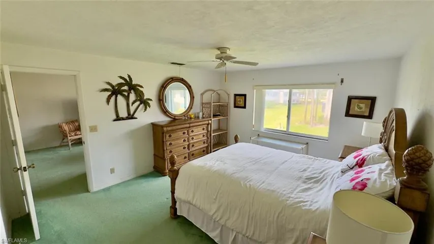 Carpeted bedroom featuring ceiling fan and radiator