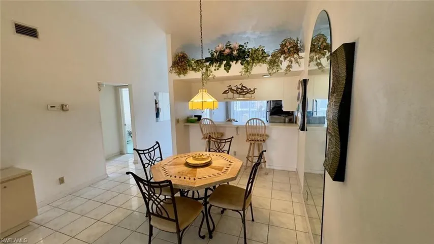 Tiled dining space featuring a high ceiling