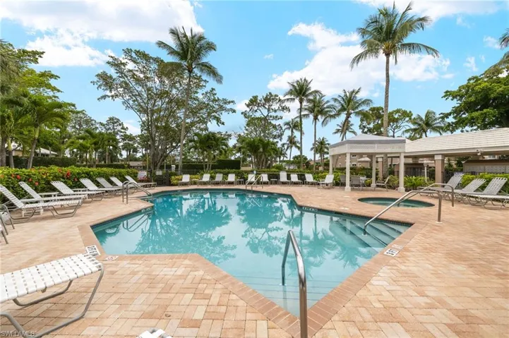 Community pool with a patio area and a community hot tub