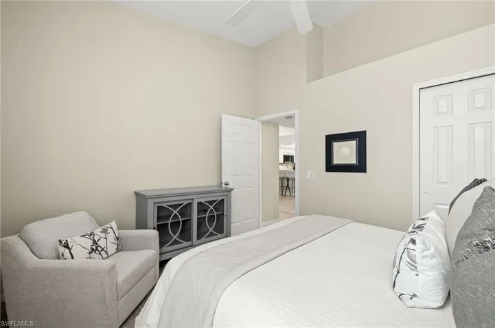Bedroom with a ceiling fan and a high ceiling