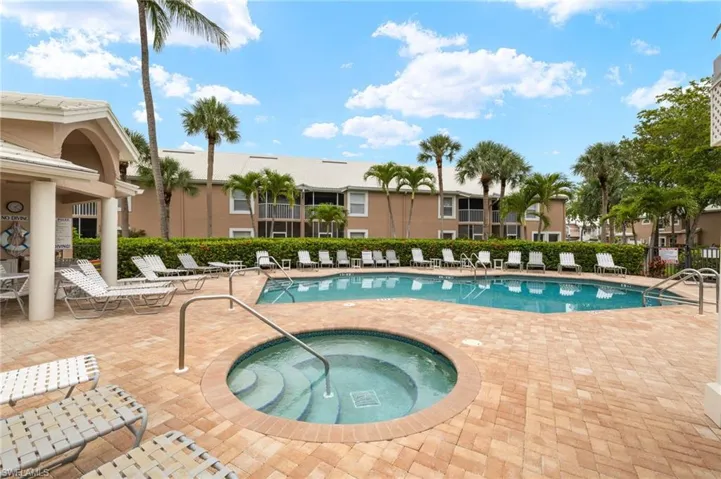 Community pool with a patio area and a hot tub