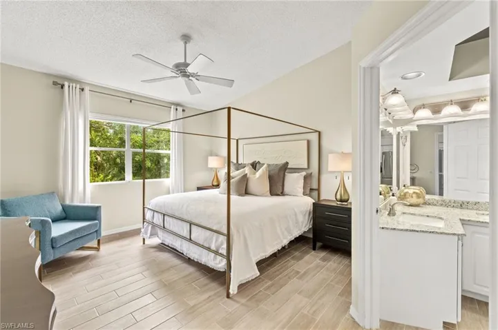 Bedroom featuring light wood-type flooring, a textured ceiling, and ceiling fan