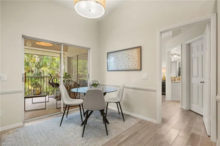 Dining area with wood finished floors and a towering ceiling