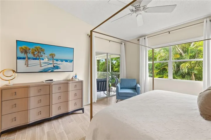 Bedroom featuring access to outside, a textured ceiling, a ceiling fan, lofted ceiling, and light wood-type flooring