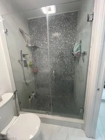 Bathroom featuring toilet and a shower stall