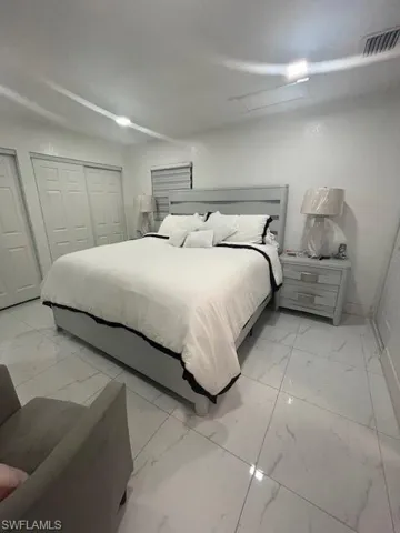 Bedroom featuring light marble finish flooring