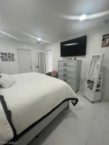 Bedroom with light marble finish flooring
