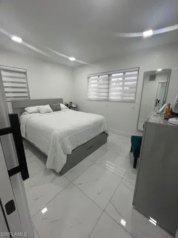 Bedroom with light marble finish floors and baseboards