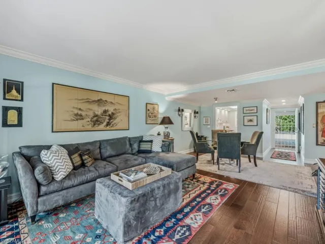 Living room featuring crown molding and dark wood-type flooring