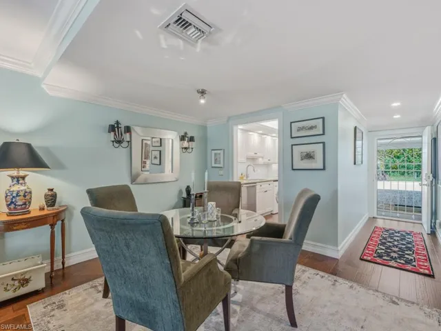 Dining room with dark wood finished floors and crown molding