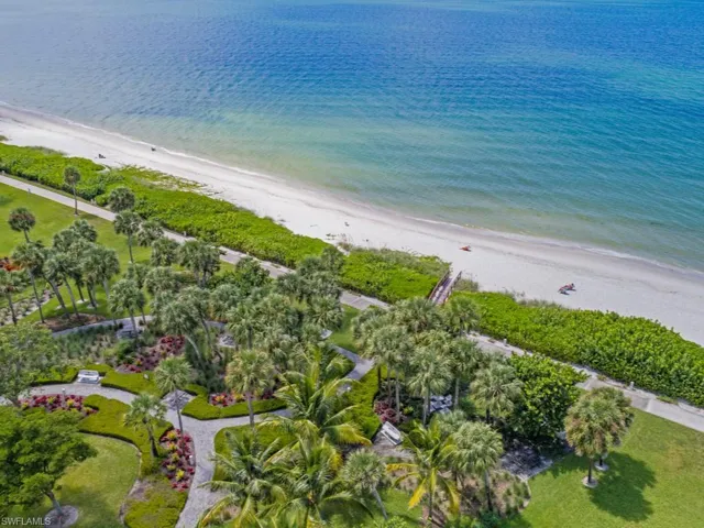 Aerial view of property and surrounding area featuring expansive beach