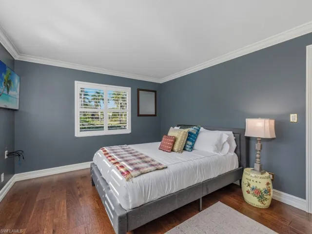 Bedroom featuring dark wood-type flooring and crown molding