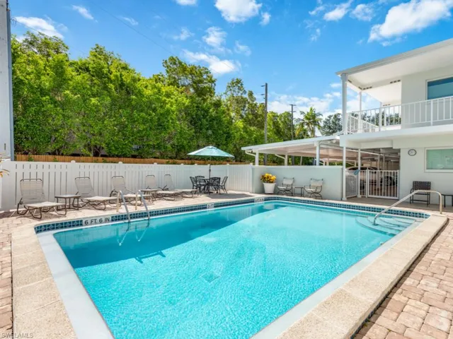 Community pool featuring a balcony, a patio, a fenced backyard, and outdoor dining space