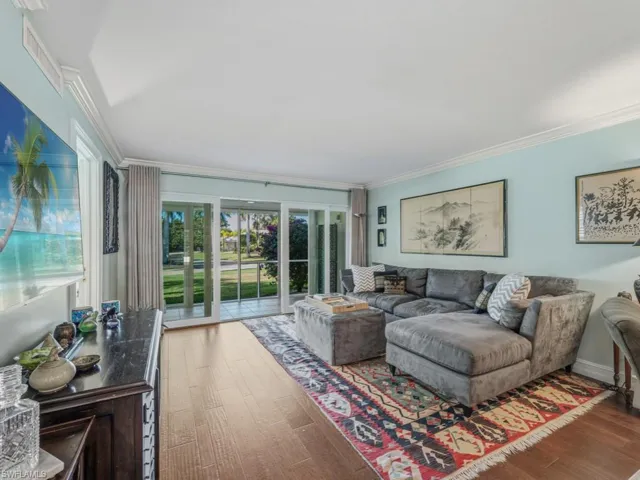 Living area with crown molding and wood finished floors