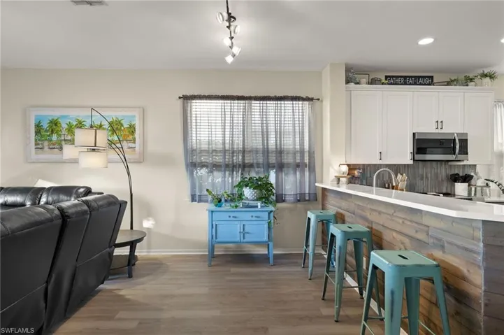 Kitchen featuring white cabinets, wood-type flooring, and backsplash