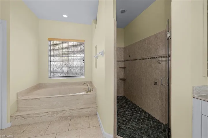 Bathroom featuring a shower stall, a bath, tile patterned floors, and vanity