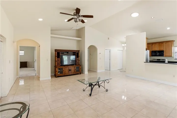 Open-concept living space featuring high vaulted ceilings, recessed lighting, and large format tile flooring