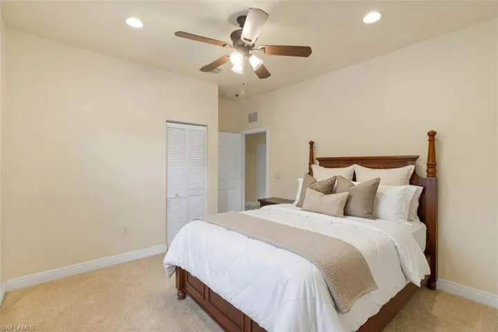 Carpeted room featuring a ceiling fan with integrated lighting, recessed lighting, and a closet with louvered bi-fold doors