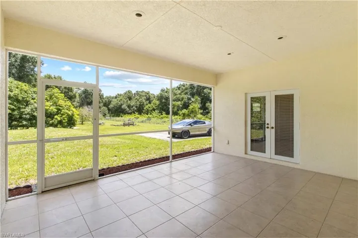 Screened patio featuring large format tile flooring and a textured ceiling with recessed lighting