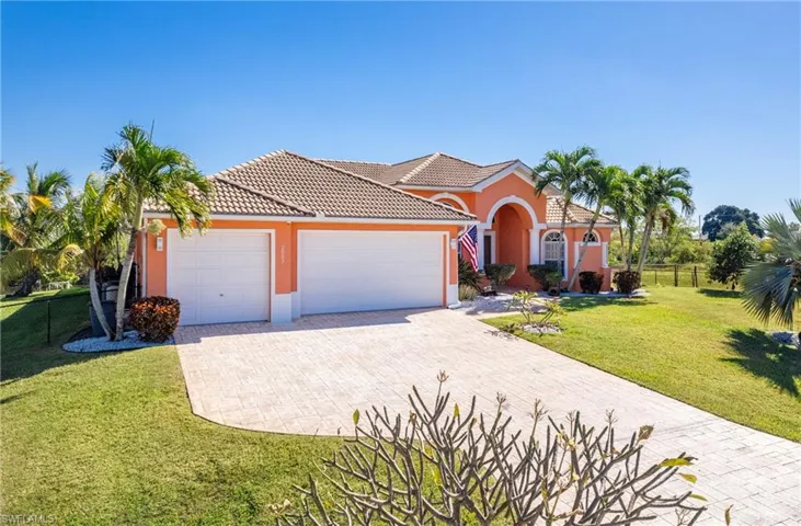 Mediterranean / spanish home featuring a garage, driveway, stucco siding, and a tile roof