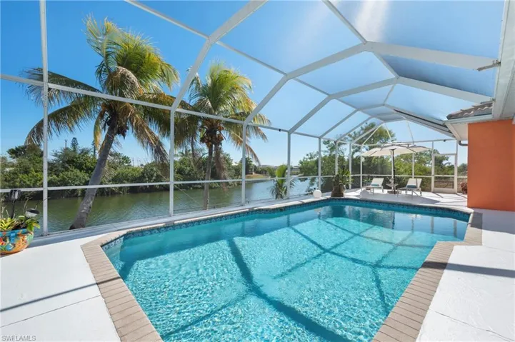 Outdoor pool featuring a patio, a lanai, a water view, and a sunroom