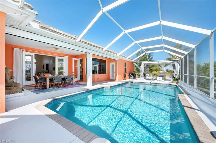 Outdoor pool with outdoor dining area, glass enclosure, a sunroom, and a patio