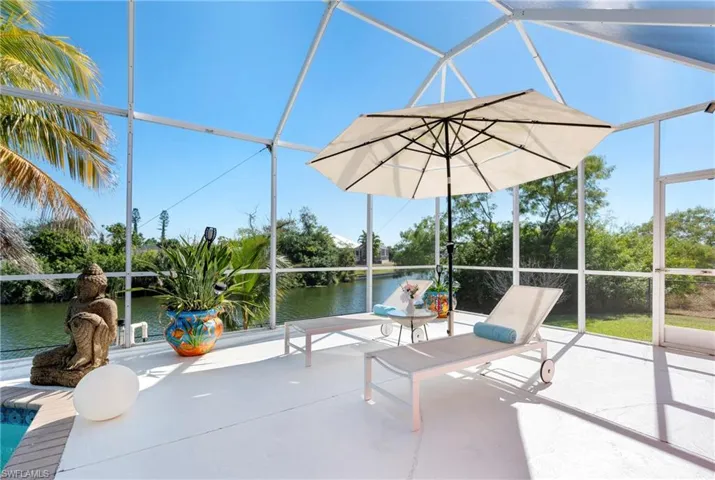 View of patio featuring a sunroom, glass enclosure, and a water view