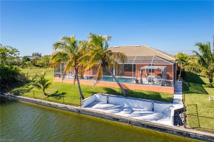 Back of house featuring a fenced backyard, a sunroom, a lanai, and a water view