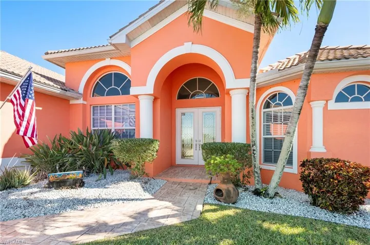 View of exterior entry featuring french doors, stucco siding, and a tile roof